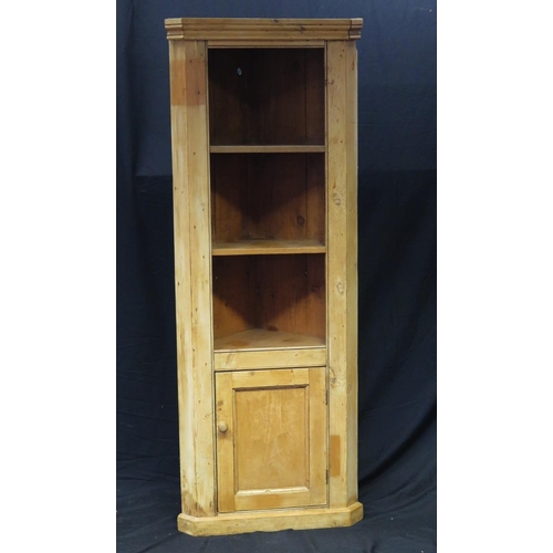 1621 - A stripped pine corner cupboard, having a moulded cornice above three open shelves with cupboard doo... 