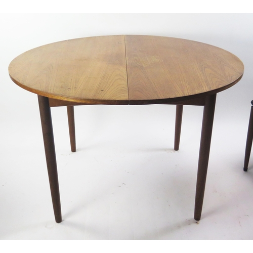 1076 - A 1970's G-Plan teak extending dining table with integral folding leaf, raised on turned legs, 150cm... 