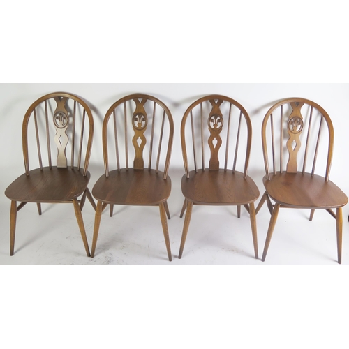 1086 - A set of four Ercol dining chairs, the oval backs with Prince of Wales feathers to the central splat... 