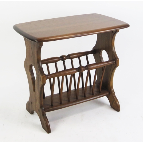 1087 - An Ercol magazine rack, with rectangular top on trestle end supports with turned spindle rack, 54.5c... 