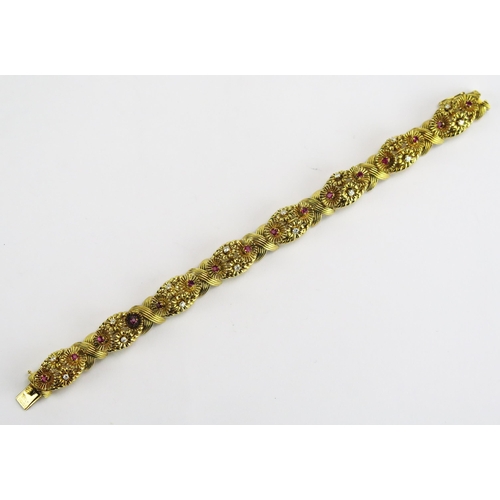 112 - A 1950's 18ct Gold, Ruby and Diamond Bracelet decorated with eight panels having stones in arranged ... 