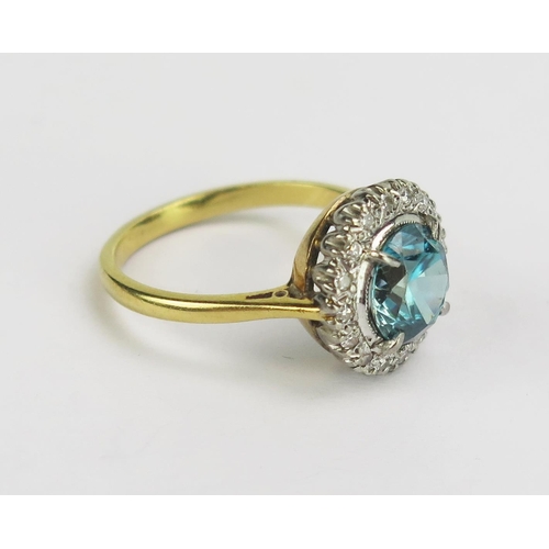 113 - An 18ct Gold, Blue Zircon and Diamond Cluster Ring, 7.54mm principal platinum claw set stone, 12.5mm... 