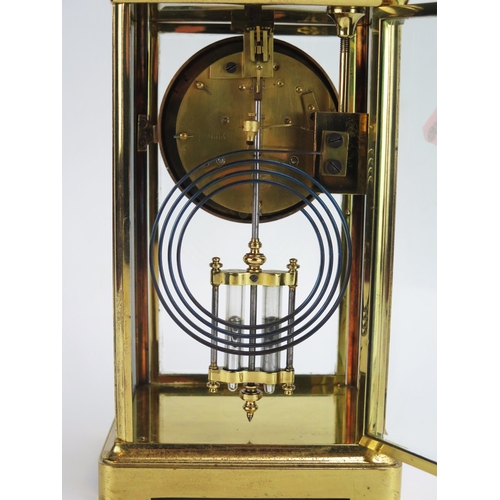 1194 - A lacquered brass four-glass mantel clock of rectangular outline, the circular movement with 9cm Ara... 