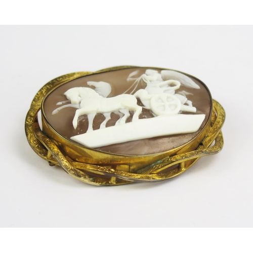 121 - A Victorian Shell Cameo Brooch in a yellow metal mount decorated with Victory riding a chariot, 57.9... 