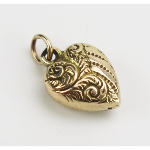 123 - An Antique Precious Yellow Metal Heart Shaped Pendant with chased foliate scroll decoration, 16mm dr... 