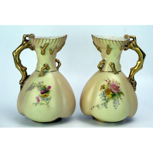 1249 - A matched pair of Royal Worcester blush ivory jugs, of lobed ovoid form, with painted floral decorat... 