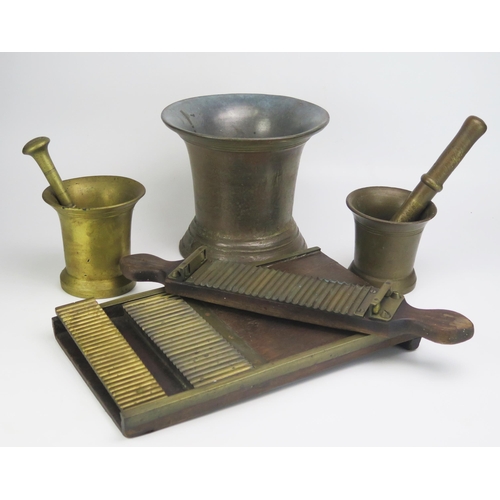 1321 - A large cast brass mortar, 20cm high, two smaller bronze pestle and mortars and a pill making machin... 