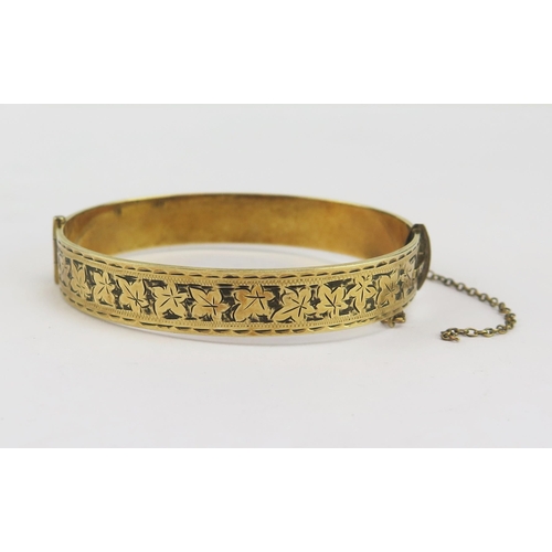 150 - A 9ct Gold (Metal Core) Hinged Bangle with chased ivy leaf decoration