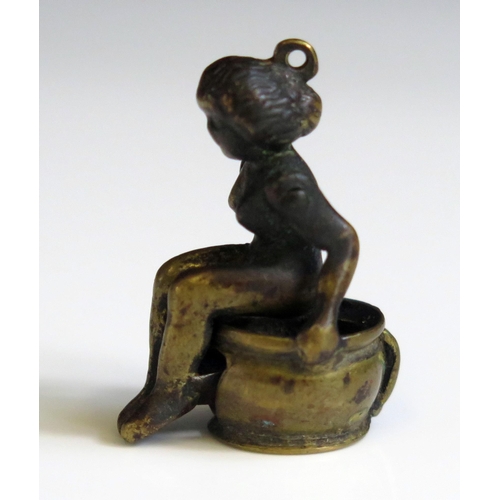 1621 - A novelty bronze cigar cutter in the form of a nude lady seated on a chamber pot, 3.5cm high.