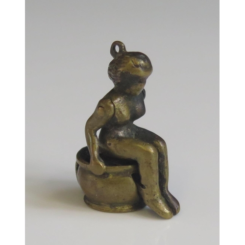 1621 - A novelty bronze cigar cutter in the form of a nude lady seated on a chamber pot, 3.5cm high.