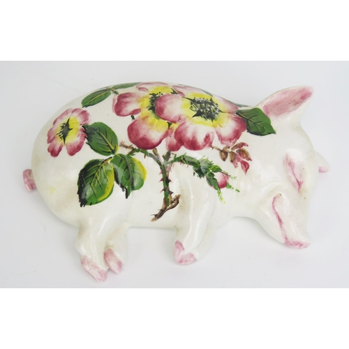 1645 - A Wemyss ware sleeping pig, with traditional painted rose decoration, signed B. Adams, impressed EXO... 