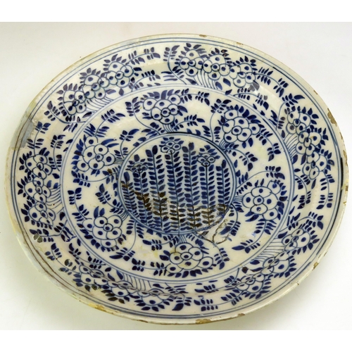 1656 - A Delft charger with blue and white foliate decoration, 34.5cm diameter, together with a lustre pott... 