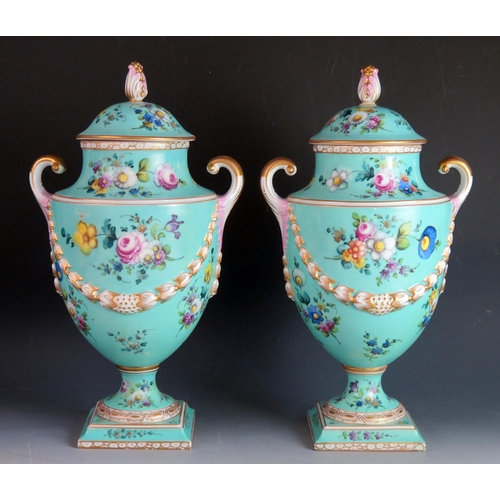 1661 - A pair of continental porcelain twin handled urns and covers, of Neo-classical outline, with gilt ga... 