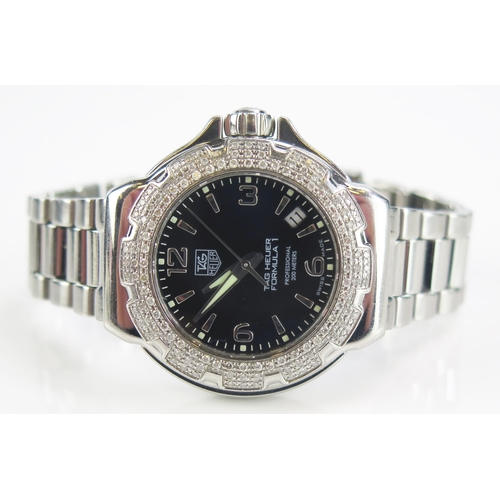 425 - A TAG Heuer Formula 1 Diamond Bezel Black Dial Wristwatch on TAG steel bracelet together with box, g... 