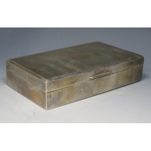 681 - A 20th century silver cigarette box, all marks worn, of rectangular outline with engine turned decor... 