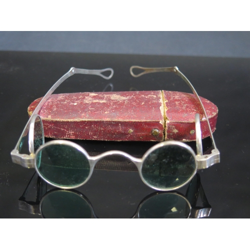 705 - A pair of silver framed sun glasses with double hinged green glass lenses, contained in a Morocco le... 