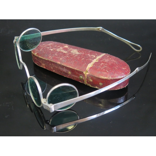 705 - A pair of silver framed sun glasses with double hinged green glass lenses, contained in a Morocco le... 