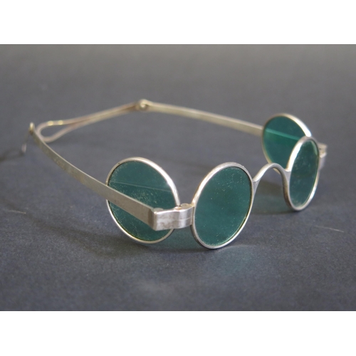 705 - A pair of silver framed sun glasses with double hinged green glass lenses, contained in a Morocco le... 