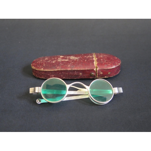 705 - A pair of silver framed sun glasses with double hinged green glass lenses, contained in a Morocco le... 