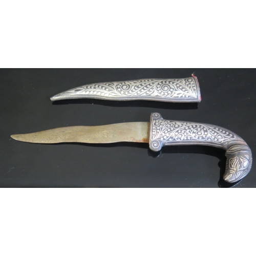 709 - A Persian dagger, with 9cm wavy Damascus blade, with silver and niello enamel handle with goat's hea... 