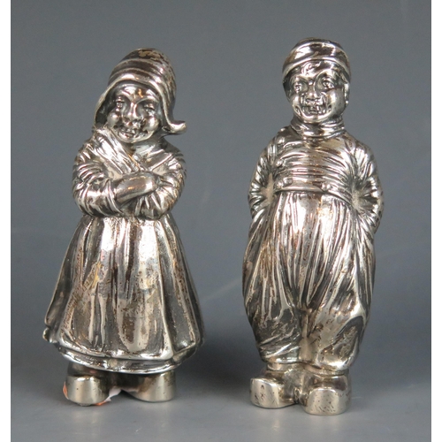 727 - A pair of continental silver novelty pepperettes, bears import marks, in the form of a Dutch boy and... 