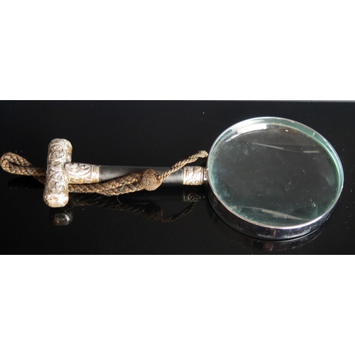 763 - A magnifying glass with ebonised and silver mounted handle, 23cm long.