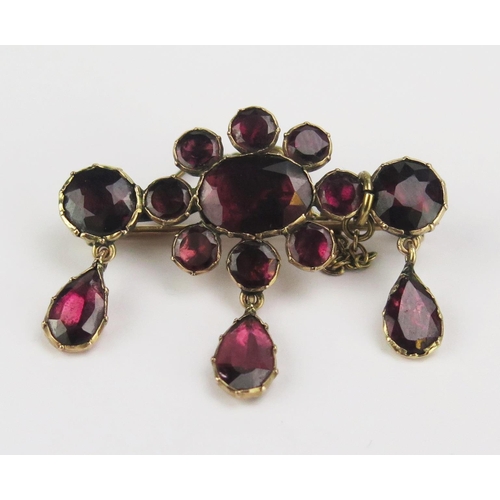 90 - A Georgian Foil Backed Garnet Brooch in a precious yellow metal setting with three suspended pear sh... 