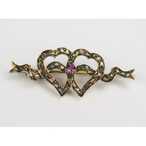 99 - An Antique Rose Cut Diamond and Pink Stone Double Heart and Ribbon Decorated Brooch in a yellow meta... 