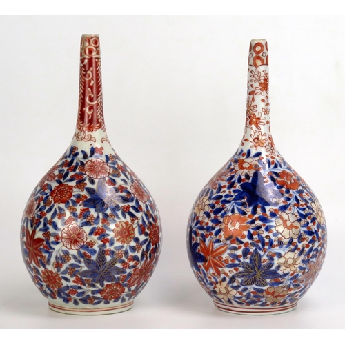 1529 - A matched pair of Japanese Imari porcelain  bottle vases, with all over floral decoration, 21cm high... 