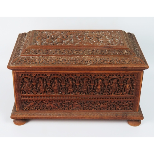 1540 - An Indian carved sandalwood casket, of rectangular outline, with shallow domed hinged lid, with all-... 