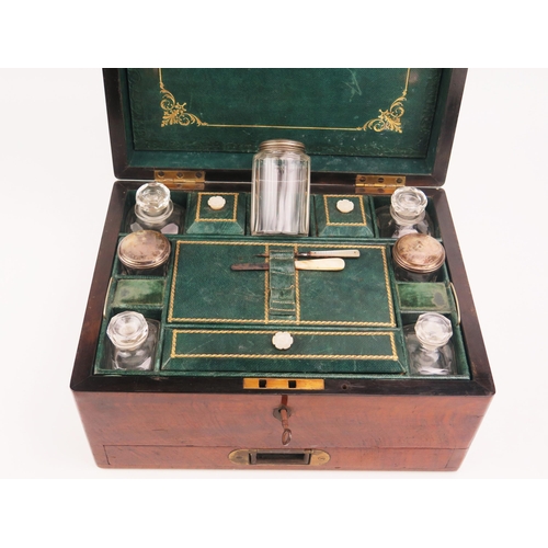 1680 - A Victorian mahogany travelling vanity box, the hinged lid enclosing a fitted interior of silver pla... 