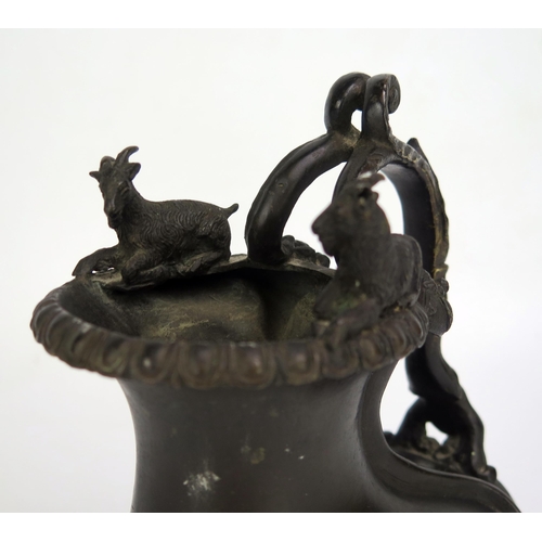 1683 - A 19th century bronze jug, of gourd shape outline the rim surmounted by two goats, with scroll handl... 