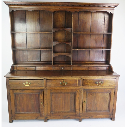 1697 - An 18th century oak dresser, the shelved superstructure with dentil moulded cornice, the base with t... 