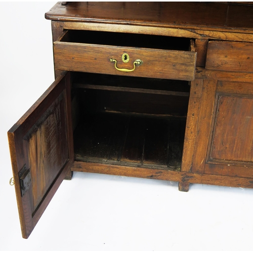 1697 - An 18th century oak dresser, the shelved superstructure with dentil moulded cornice, the base with t... 