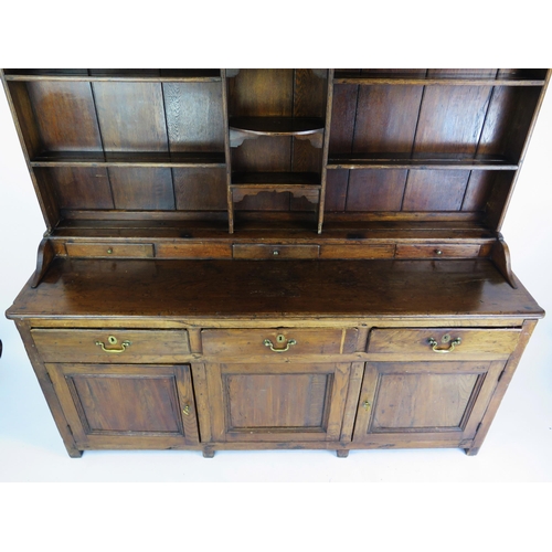 1697 - An 18th century oak dresser, the shelved superstructure with dentil moulded cornice, the base with t... 