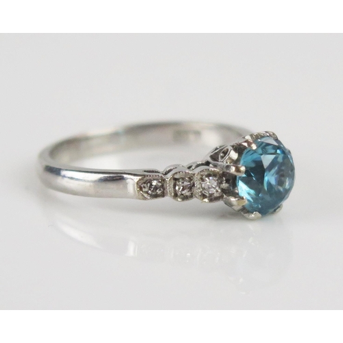 283 - An 18ct White Gold, Blue Zircon and Diamond Ring, 6.3mm principal stone set with three diamonds to e... 