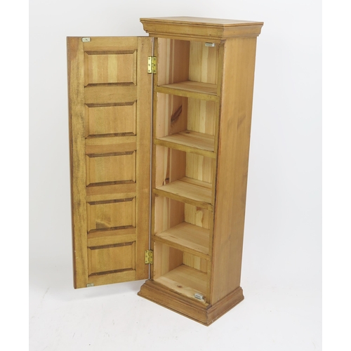 1700 - A stripped pine tower cupboard, with hinged mock drawer door, enclosing shelving, on a plinth base, ... 