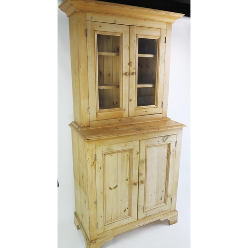 1701 - A Victorian stripped pine dresser, the upper part with a moulded cornice and a pair of glazed panel ... 