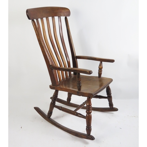 1704 - A 19th century elm and beech rocking chair with lathe back, swept arm supports and solid seat on tur... 