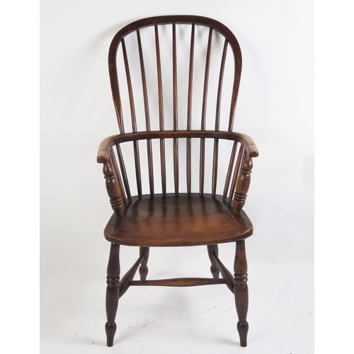 1705 - A 19th century elm Windsor style elbow chair with arched stick back, solid seat on turned under fram... 