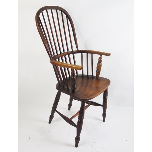 1705 - A 19th century elm Windsor style elbow chair with arched stick back, solid seat on turned under fram... 