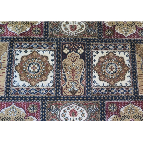 1719 - A Persian design carpet of panelled design with medallions and palmettes, enclosed by a triple flora... 