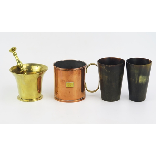 1179 - A pair of horn beakers, 10.5cm high, a brass pestle and mortar, a copper measure. (4).