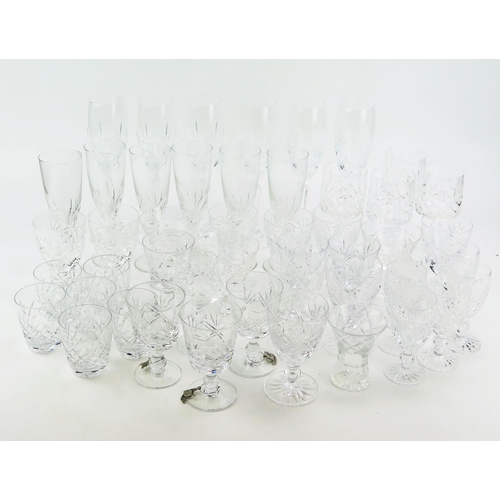 1242 - A collection of part suites of cut glass drinking vessels, including champagne flutes, wine glasses,... 