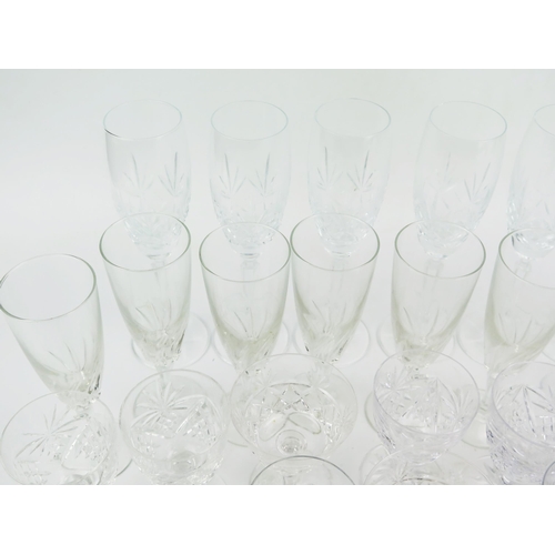 1242 - A collection of part suites of cut glass drinking vessels, including champagne flutes, wine glasses,... 