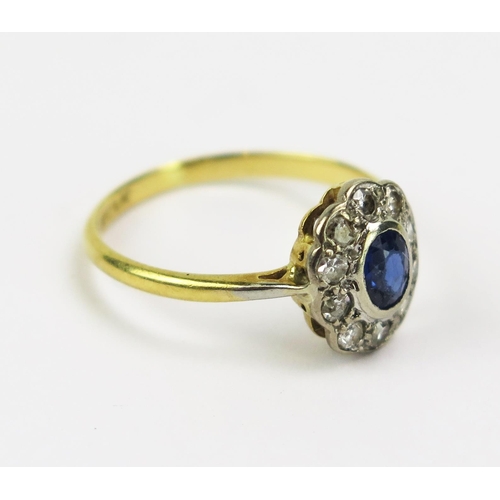 304 - An 18ct Gold, Sapphire and Diamond Cluster Ring in a platinum setting, 10.8x9mm head, size M.5, stam... 