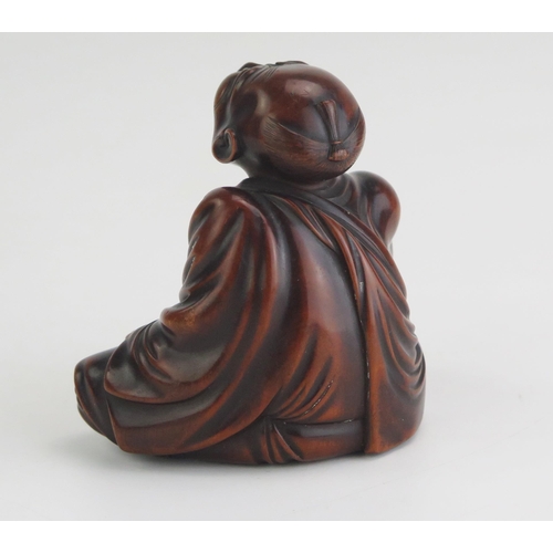 153 - A Carved hardwood netsuke of a professional sneezer seated with his right hand raised, holding a tic... 