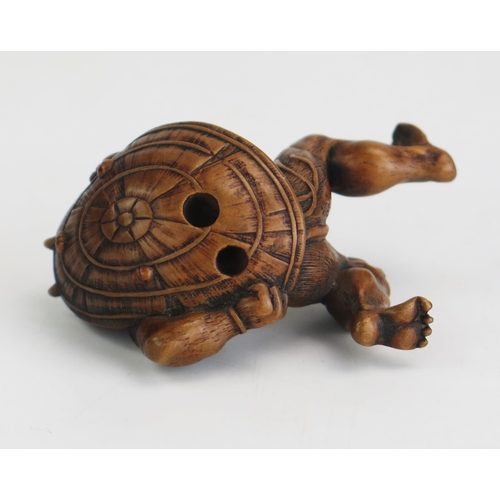 154 - A Japanese carved boxwood netsuke in the form of an oni carrying a shield on his back, signed, 5.5cm... 