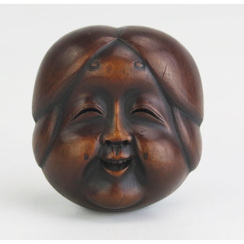 155 - A Japanese carved boxwood netsuke of a female noh theatre mask, signed possibly Gyokushu, to the ivo... 