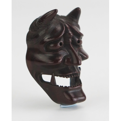 156 - A Japanese carved boxwood netsuke of a noh theatre Hannya mask, signed Doraku, 4.5cm high. Meiji per... 